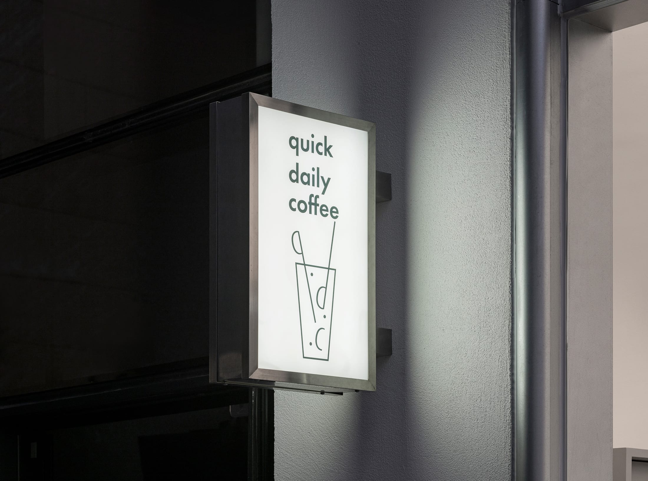 Exterior view of QDC Cafe with its rounded aluminum curtain wall and minimalist signage.