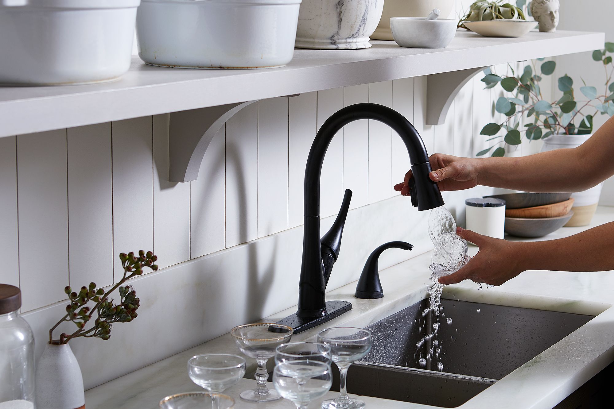 A grey Room Essentials 12-quart plastic dishpan being used in a single-basin kitchen sink.