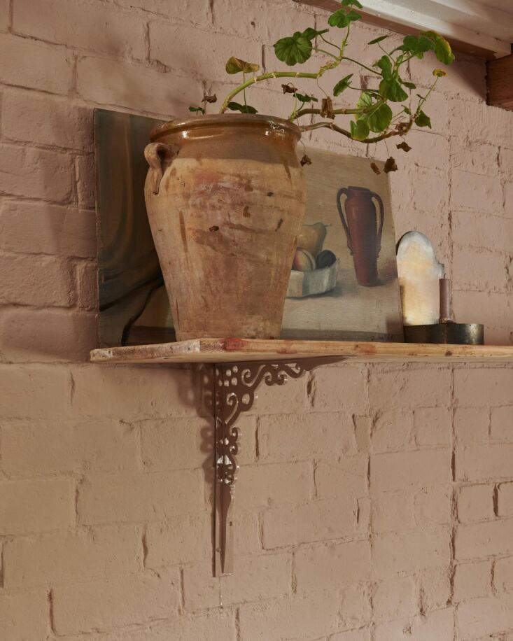 Painted cast iron brackets showing a layered texture that matches the wall color.