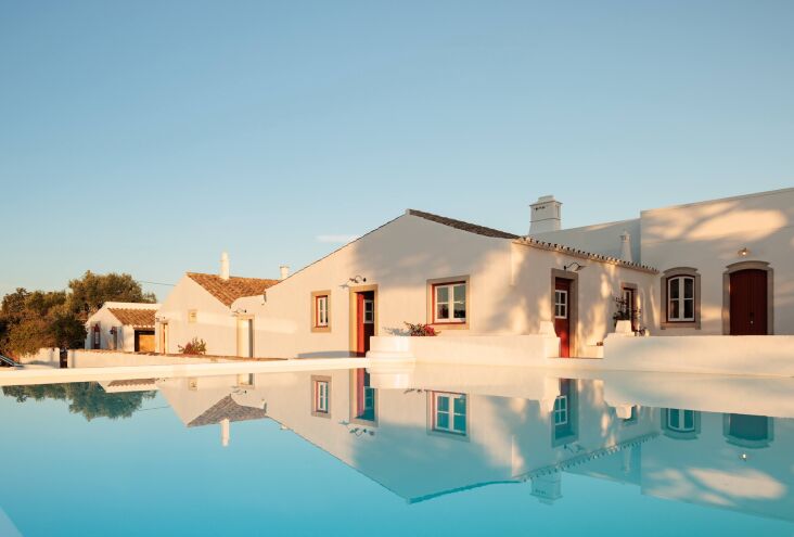 A modern swimming pool built within the stone walls of a former farm water storage basin.