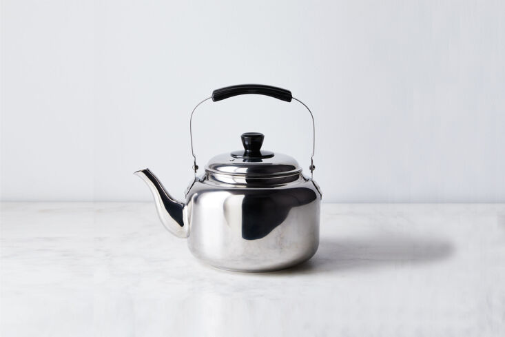A high-gloss polished stainless steel teakettle with a contemporary shape.