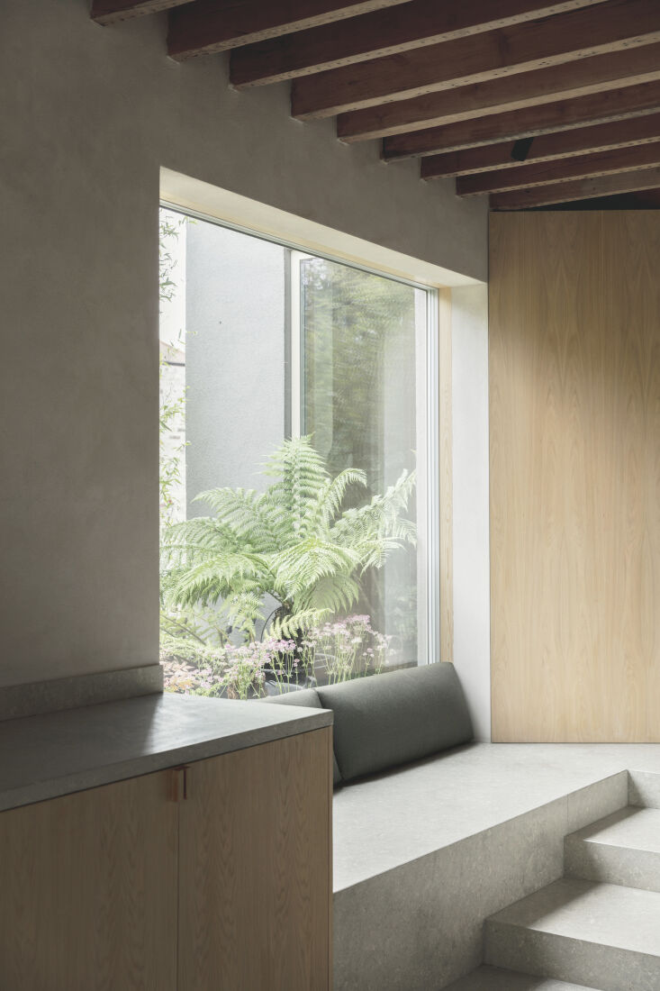 A cozy window seat with triple-glazed Velfac windows in a modern kitchen setting.
