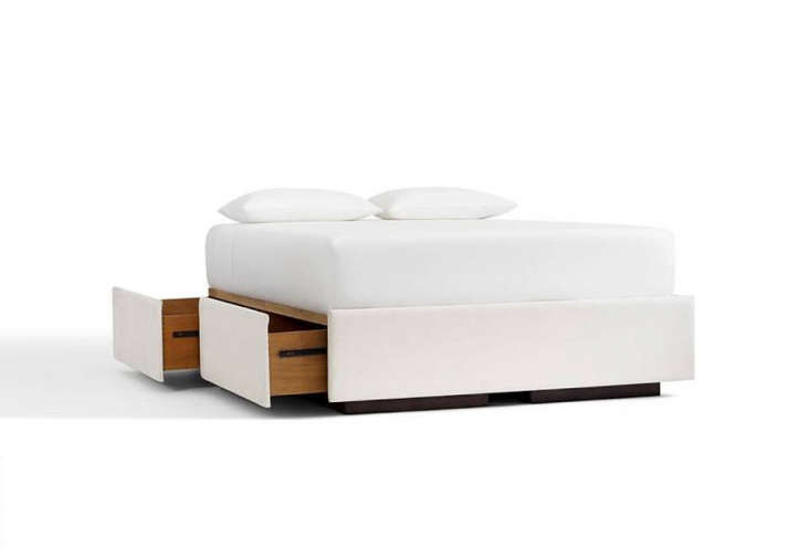 A classic Pottery Barn upholstered platform bed with built-in storage drawers at the foot and sides.