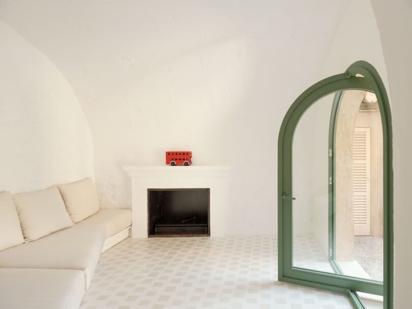 Minimalist living room with arched ceilings, white walls, and a checkered floor.