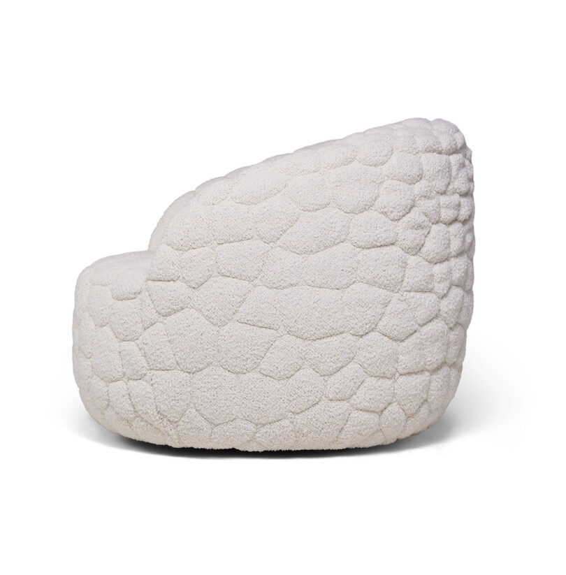 Side view of the rounded, white upholstered Introvert Chair highlighting its pebble-like silhouette.