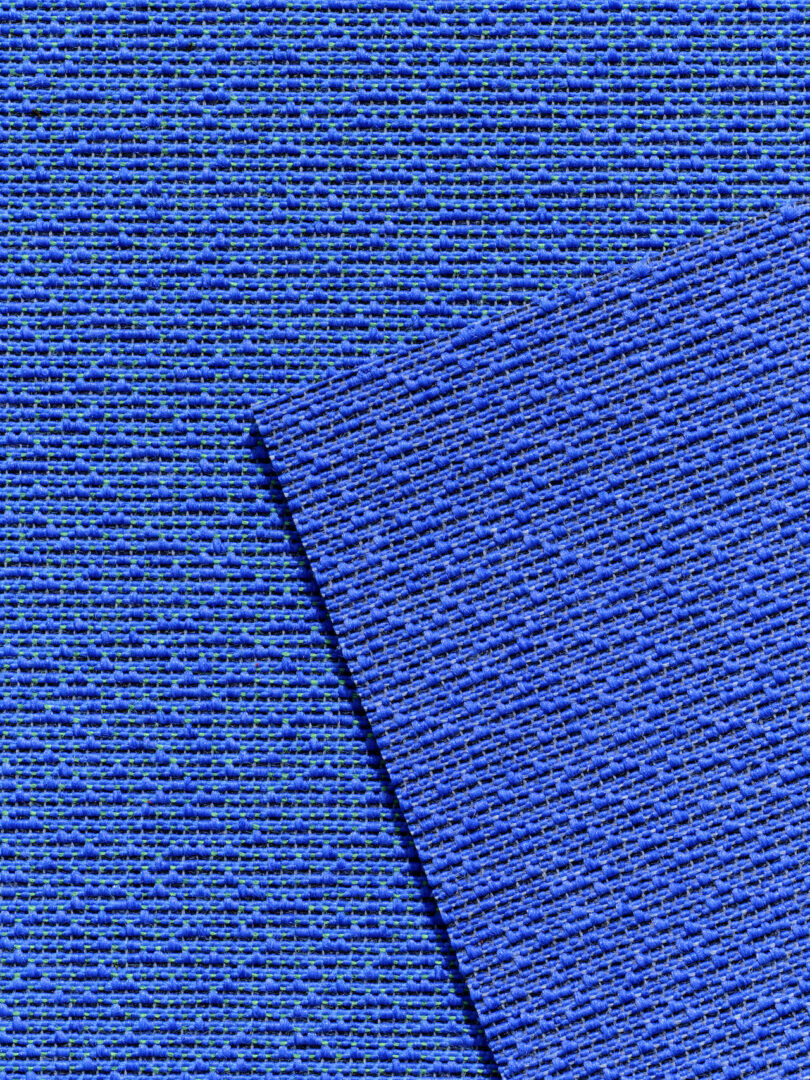 Extreme close-up of blue woven fabric showing detailed fiber texture.