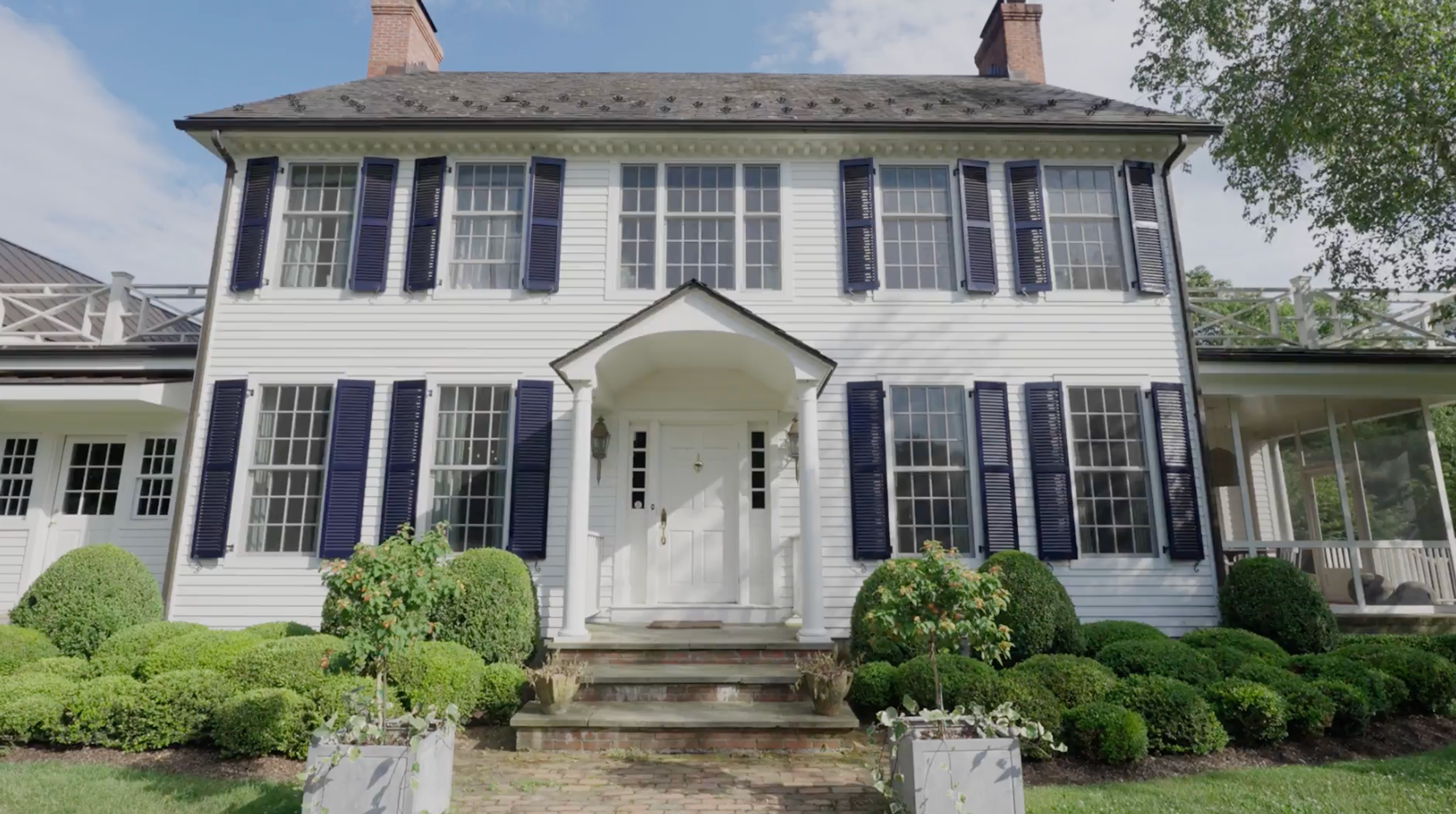 The exterior entrance of Julia Brown’s Millbrook home surrounded by greenery.