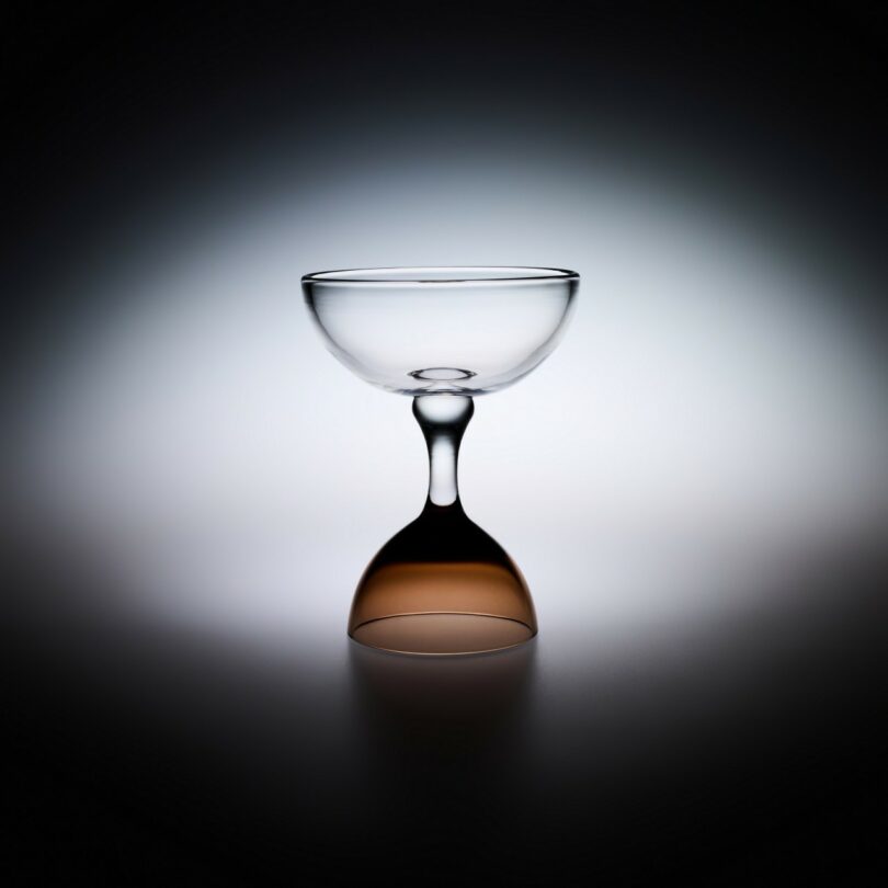 Two clear glass coupes joined symmetrically at the base to demonstrate artisanal glassblowing precision.