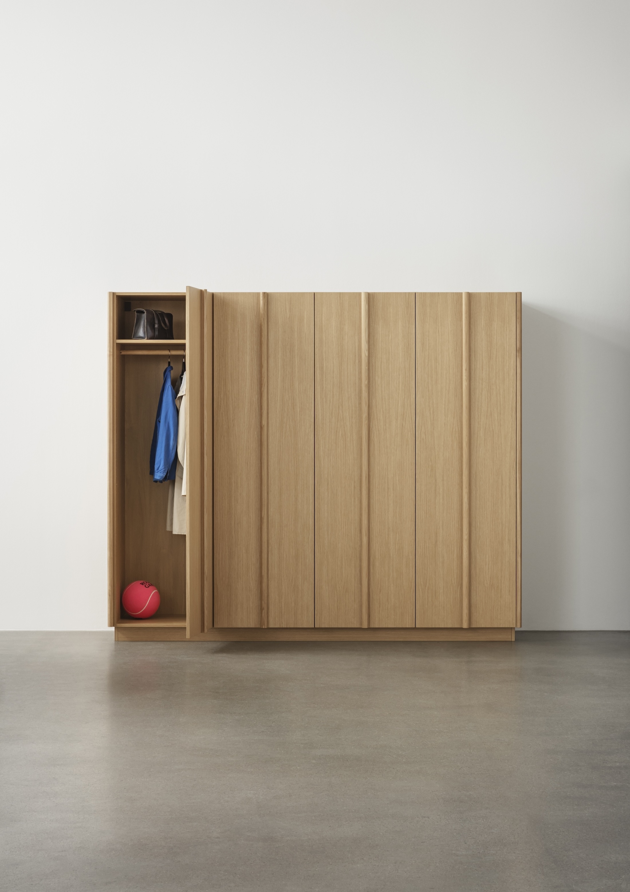 An oak wardrobe from the Reform Column collection with integrated sculptural handles.