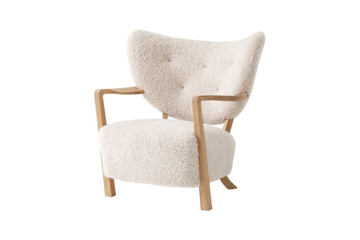 &Tradition Wulff ATD2 lounge chair with curved wooden legs and plush sheepskin upholstery.