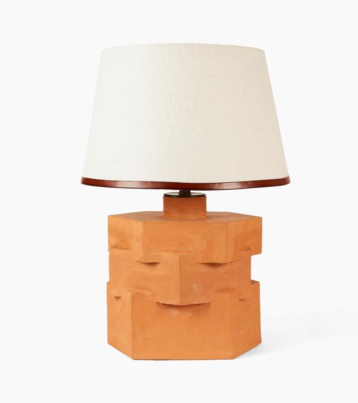 An architectural ceramic lamp with a leather-trimmed shade.