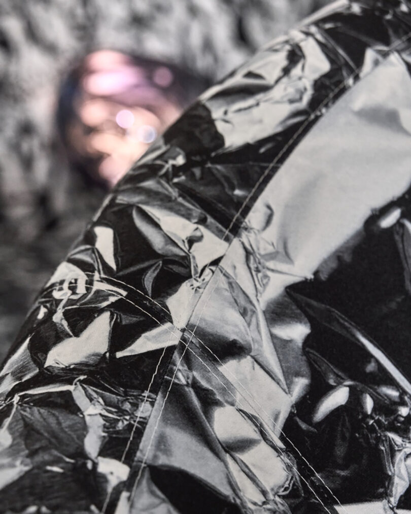 Extreme close-up of a crinkled, reflective metallic surface showing intricate texture and light play.