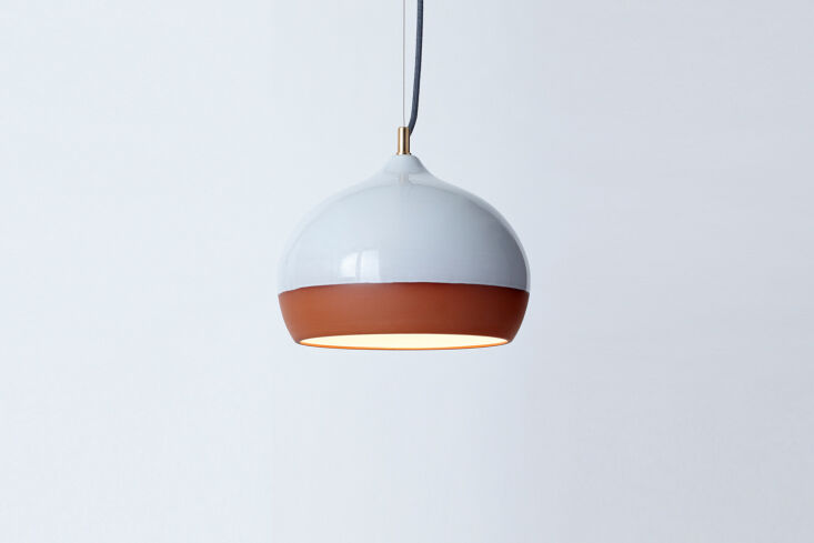 A medium-sized terracotta pendant light with a simple sculptural shape.