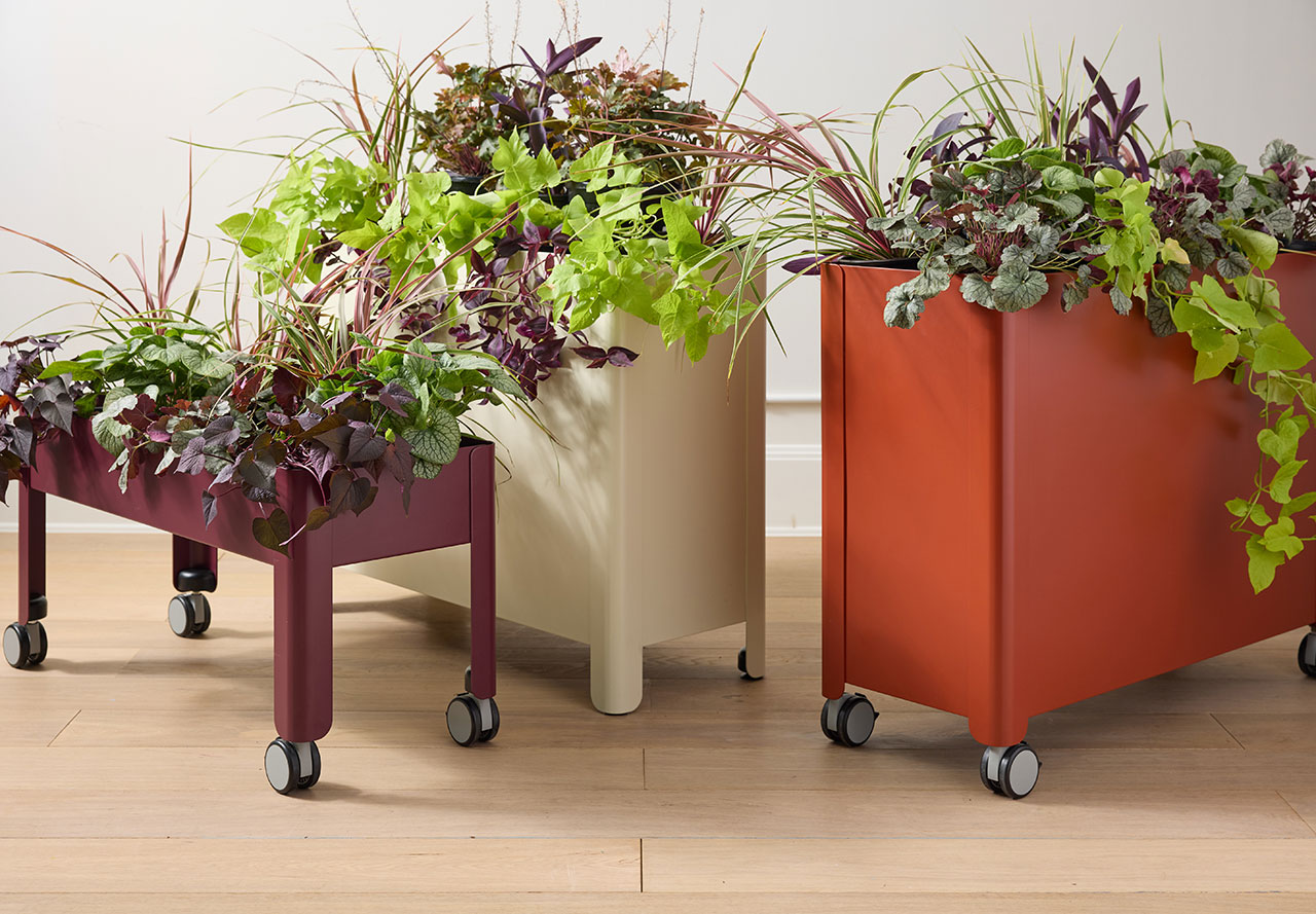 A modern office table seamlessly merged with indoor plants as part of the Plantable collection.