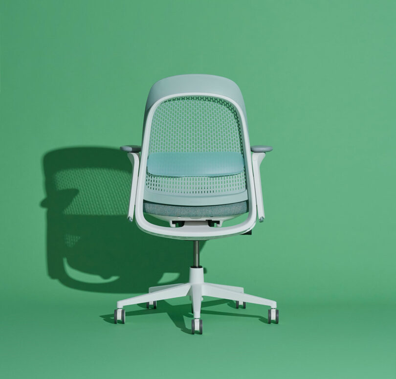 A light blue Haworth Breck chair against a green background.
