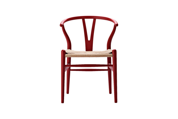 The Carl Hansen & Son CH24 Wishbone Chair featuring a soft red frame and natural paper cord seat.