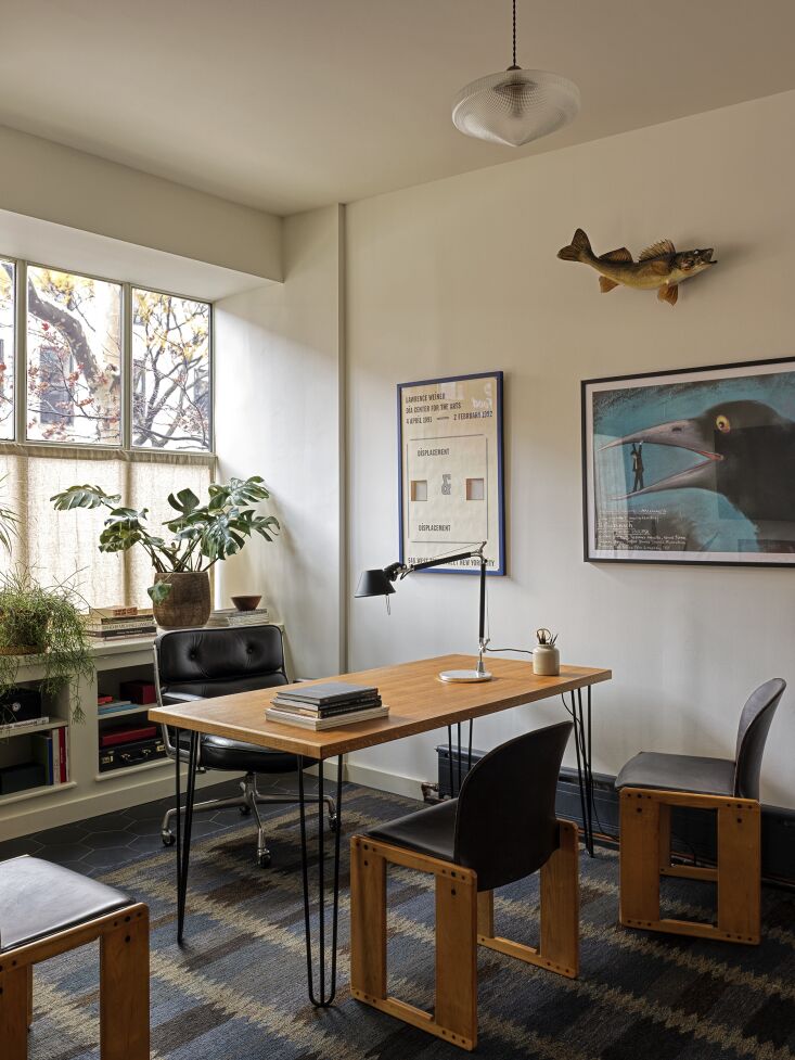 Executive desk setup with a vintage Charles Pollock chair and curated artwork on the wall.