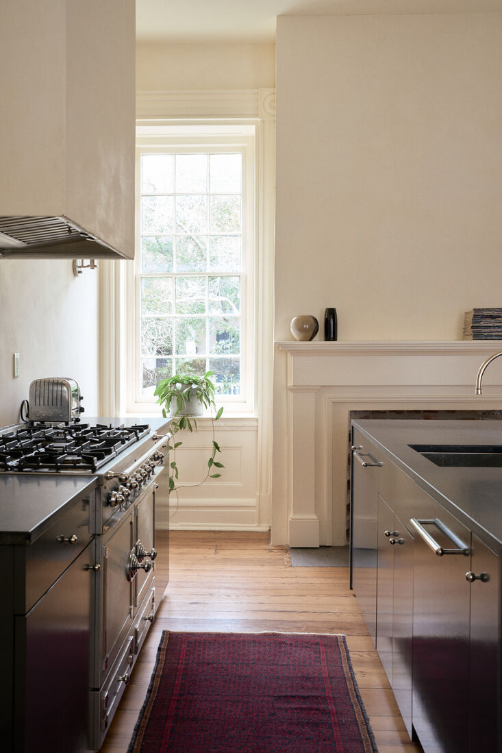 A gourmet kitchen featuring a white La CornuFé dual fuel range and minimalist cabinetry.