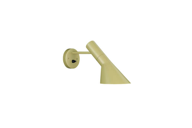 A yellow-green AJ Wall Lamp mounted on a wooden wall.