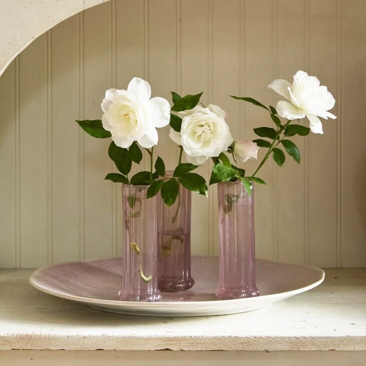 Small colorful glass vases in varied shapes on a wooden surface.