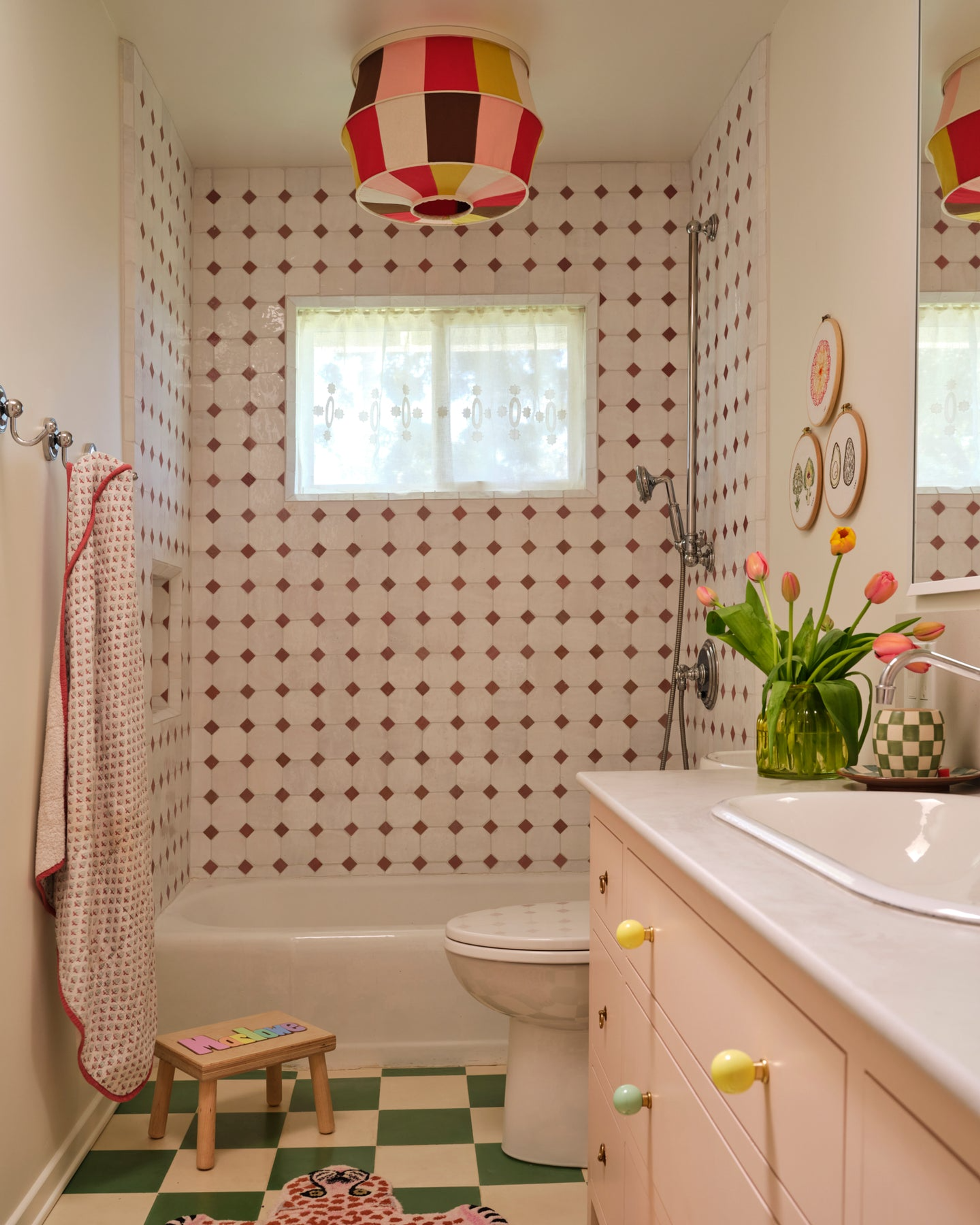 A colorful decorative sconce cover by Tulip used in a bathroom setting.