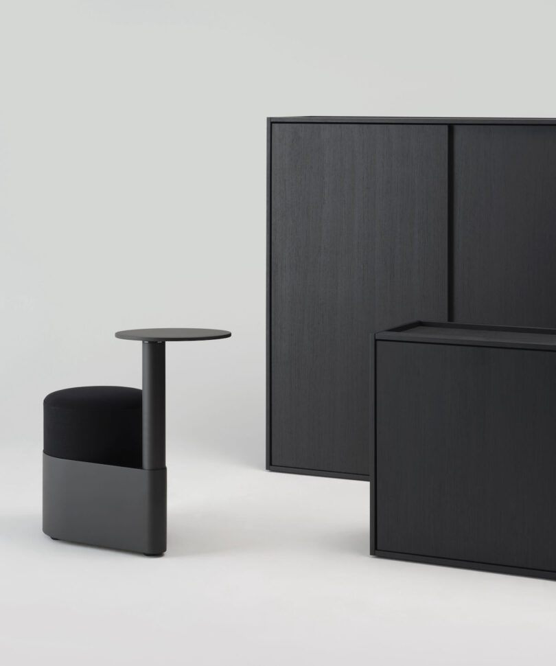 A black pony chair positioned next to minimalist office storage units.