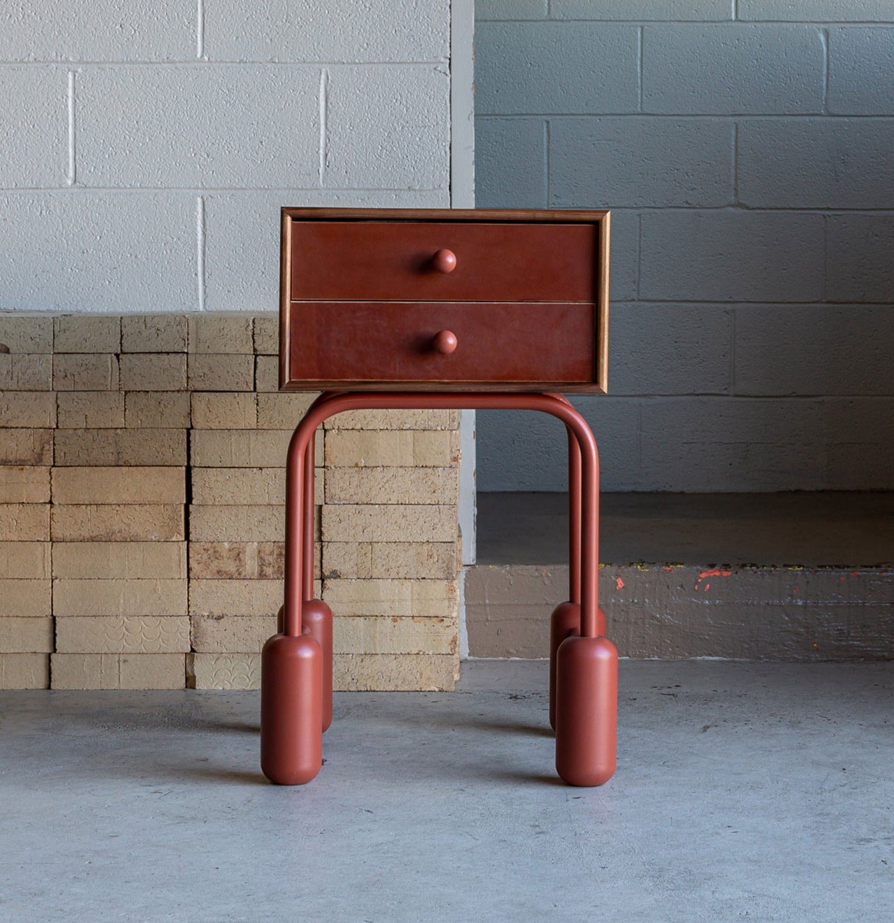 A minimalist wooden nightstand with rounded legs and soft edges.