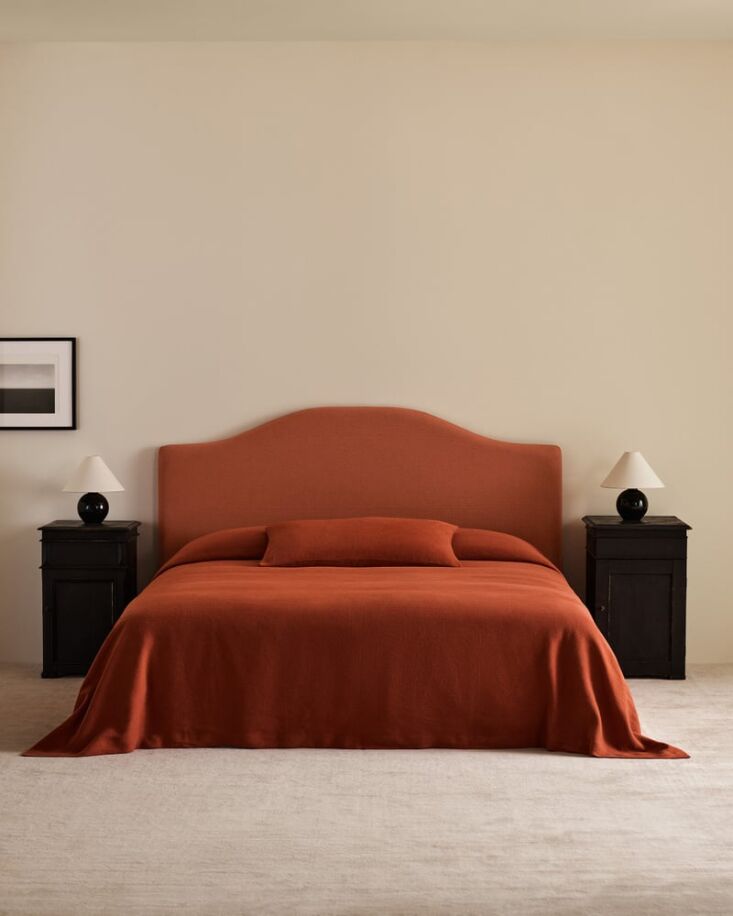A burnt red linen bed cover styled in a modern, minimalist Nordic bedroom setting.
