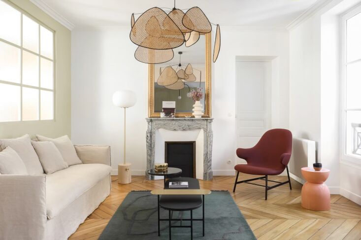 A cozy apartment corner with a small sofa and lounge chair styled in a contemporary European aesthetic.